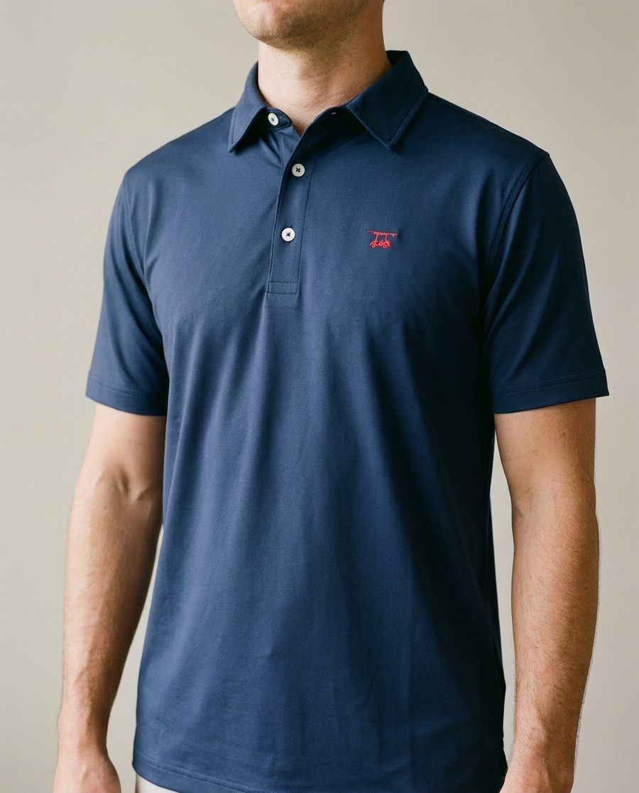 Close crop of the Solid Medieval navy Albatross polo showing collar, placket and cart logo