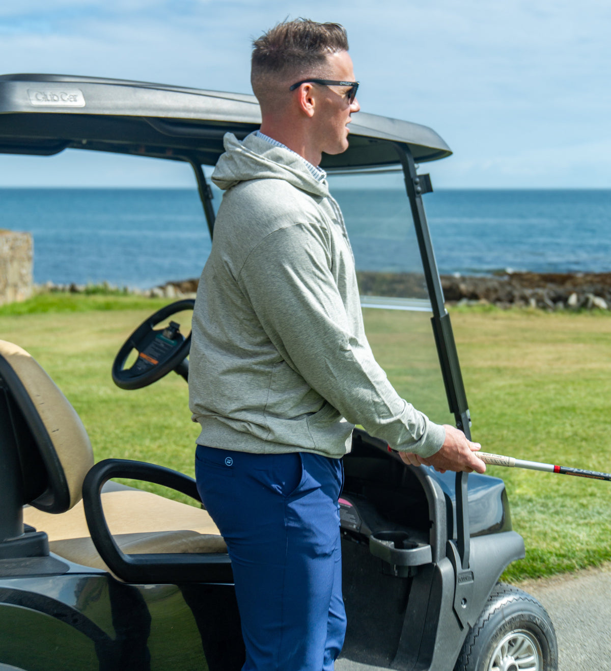 Golfer beside a golf cart above the Atlantic on Bald Head Island