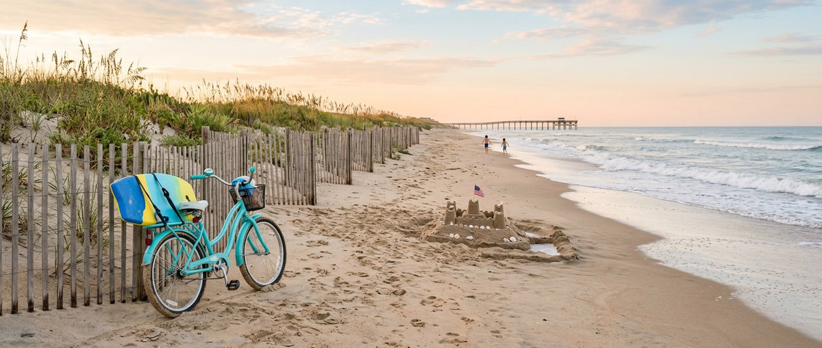 Kid's beach cruiser with a boogie board against a dune fence, sandcastle and pier on a Carolina beach morning